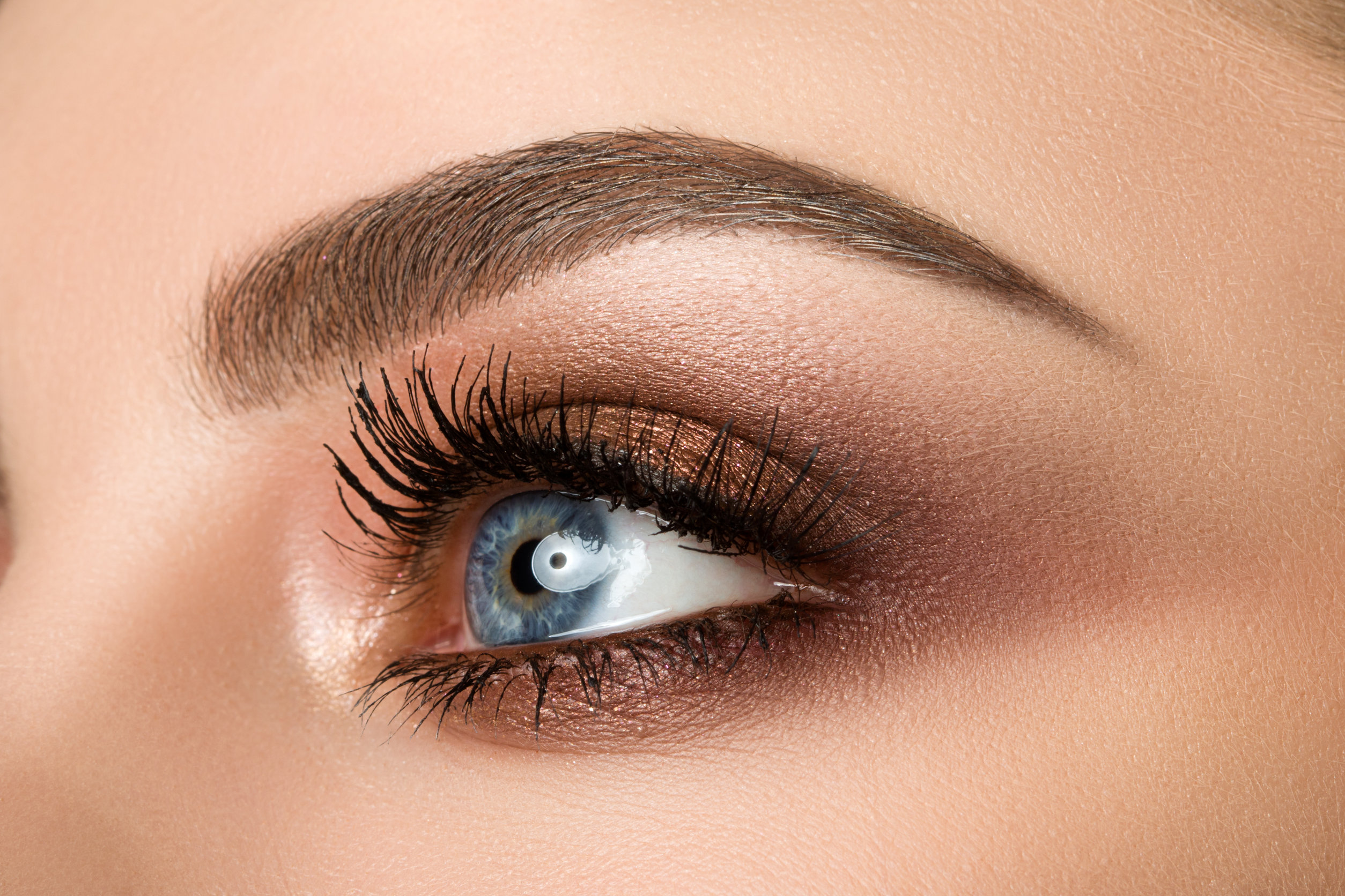 close up of woman eye with beautiful brown smokey eyes makeup